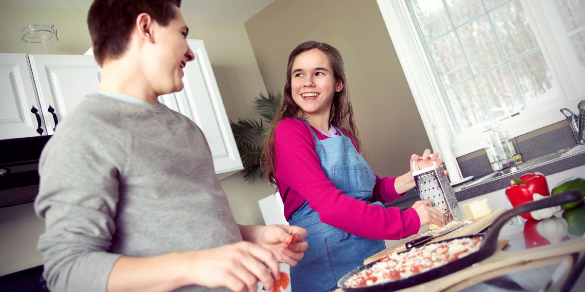 Fratello e sorella cucinano insieme la pizza