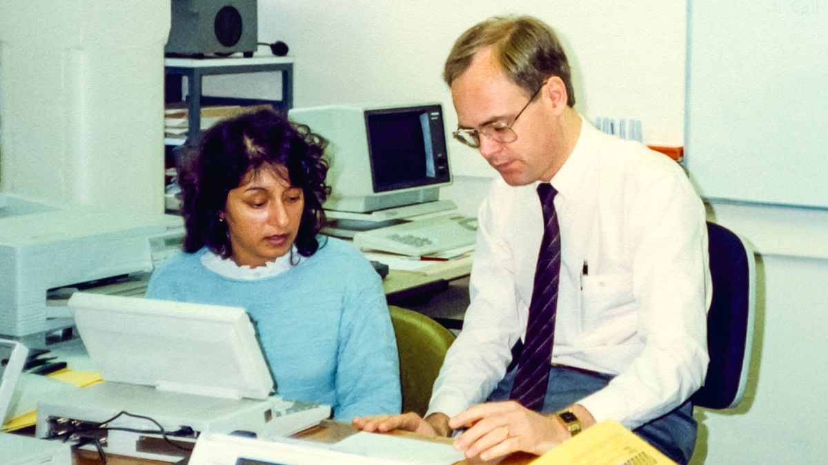 Kamal seduta davanti a un computer mentre riceve formazione da un fratello.