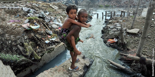 Bambini giocano dove terra e acqua sono molto inquinate