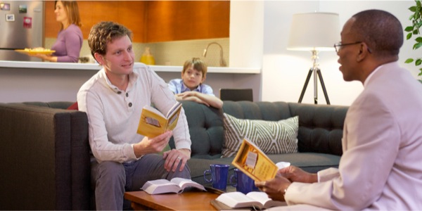 Uomo che non fuma più e sta studiando la Bibbia; la famiglia è felice