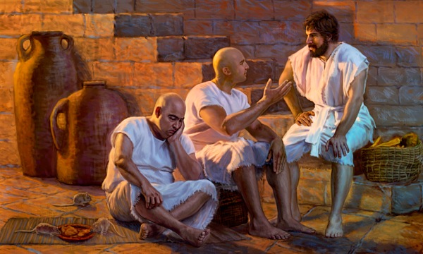 Giuseppe siede con i suoi compagni di prigionia