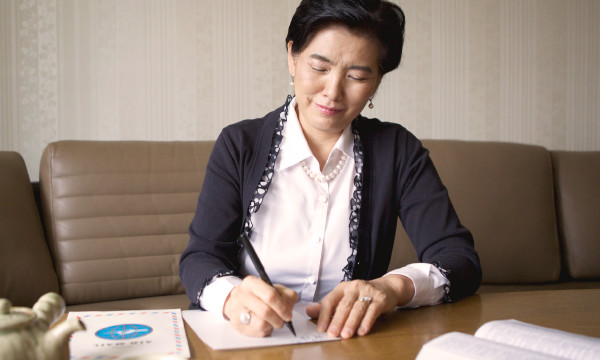 Una donna anziana scrive una lettera