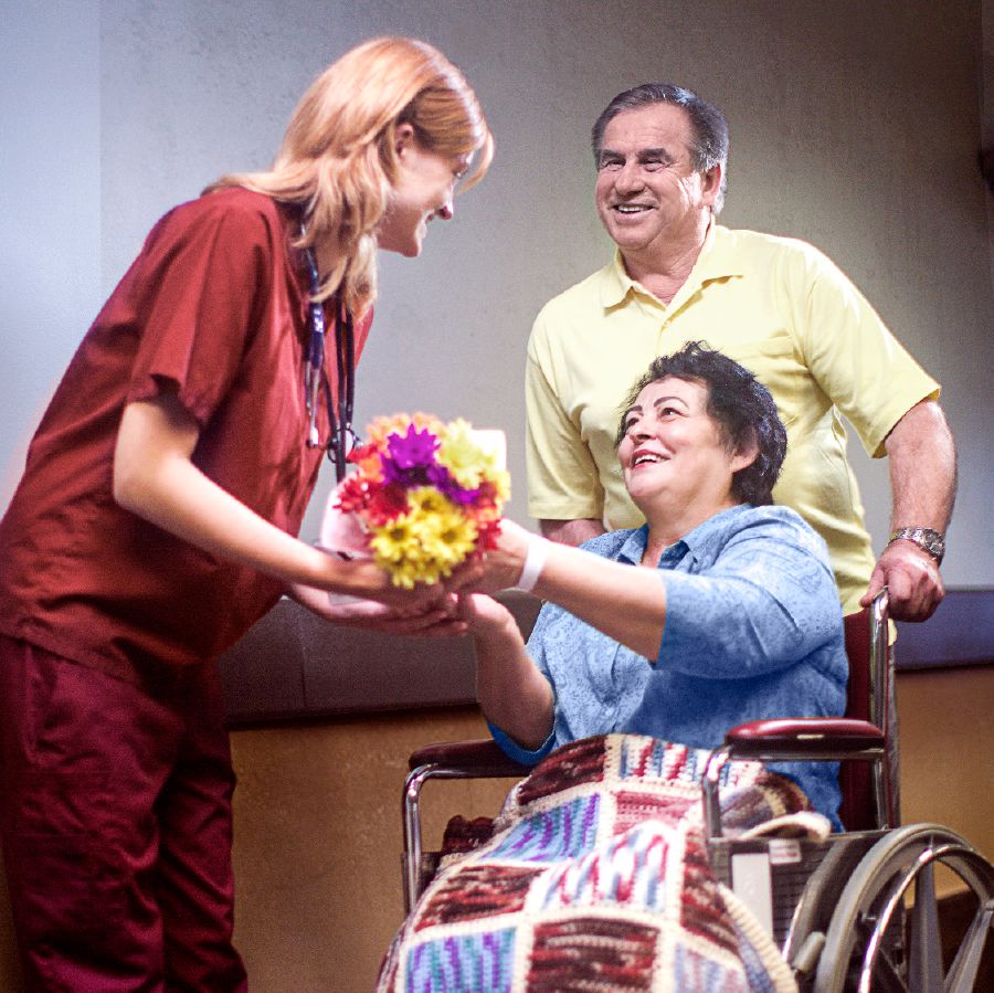 Una coppia dà un mazzo di fiori a una dottoressa