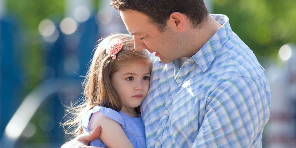 Un padre tiene in braccio la sua bambina