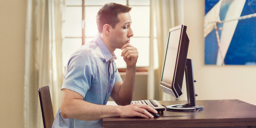 Un uomo guarda pensieroso lo schermo del suo computer