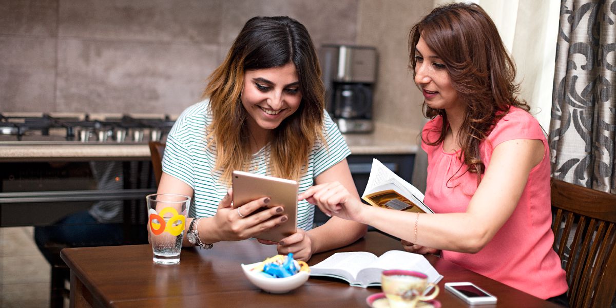 Una sorella studia con una donna in lingua curda