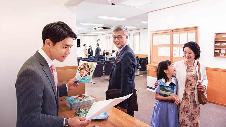 文書が依頼した通りに届いているかを確認している若い兄弟と，それをほほ笑んで見守る年長の兄弟。