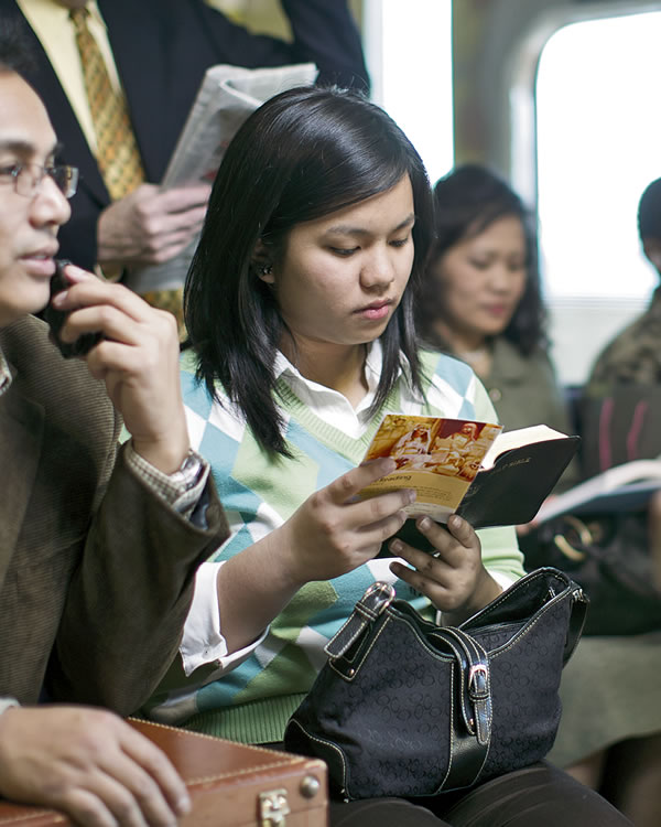 女性が列車の中で聖書を読む