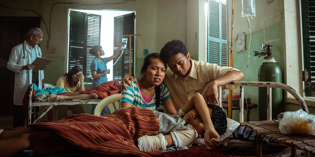Wong tuwa sing lagi nunggoni anaké sing bar diamputasi ing rumah sakit.