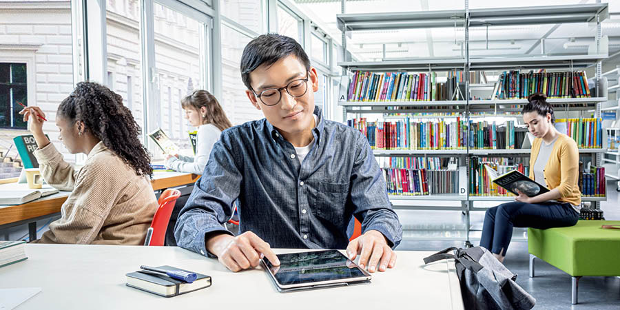 Cah enom ing perpustakaan maca brosur ”Apa Makhluk Hidup Ana sing Nyiptakké?” nganggo tablèt.
