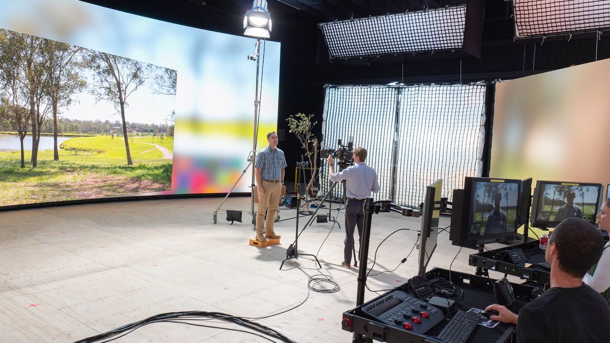 Ing studio, ana sedulur lanang lagi ngadeg ing ngarepé video wall sing nampilké gambar taman. Sedulur liyané lagi nyoba lan ngecèk peralatané.