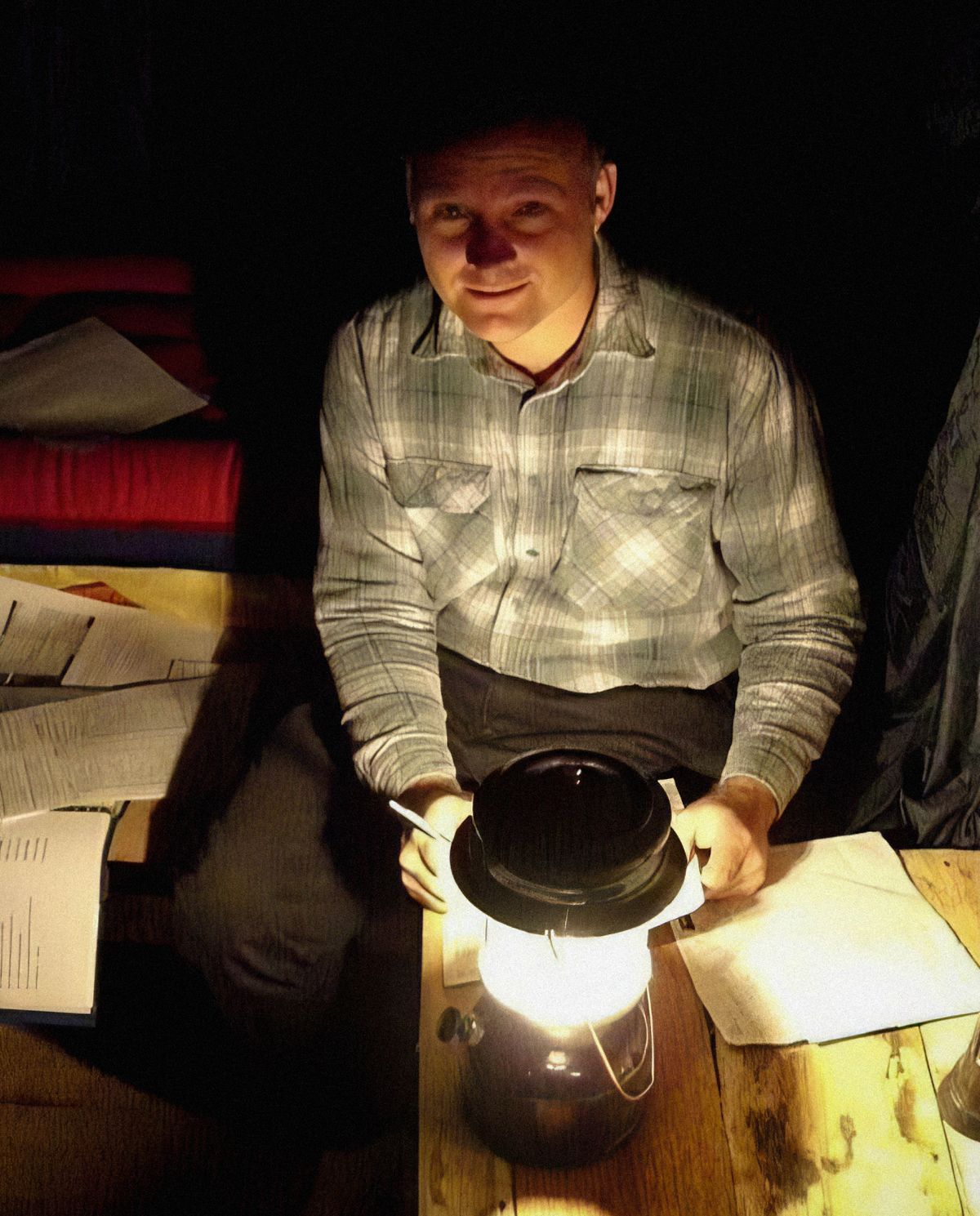Warren nggawé laporan dipadhangi lampu téplok.