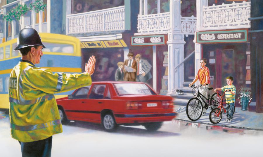 경찰관이 소년들에게 길을 건너지 말고 기다리라고 하는 모습