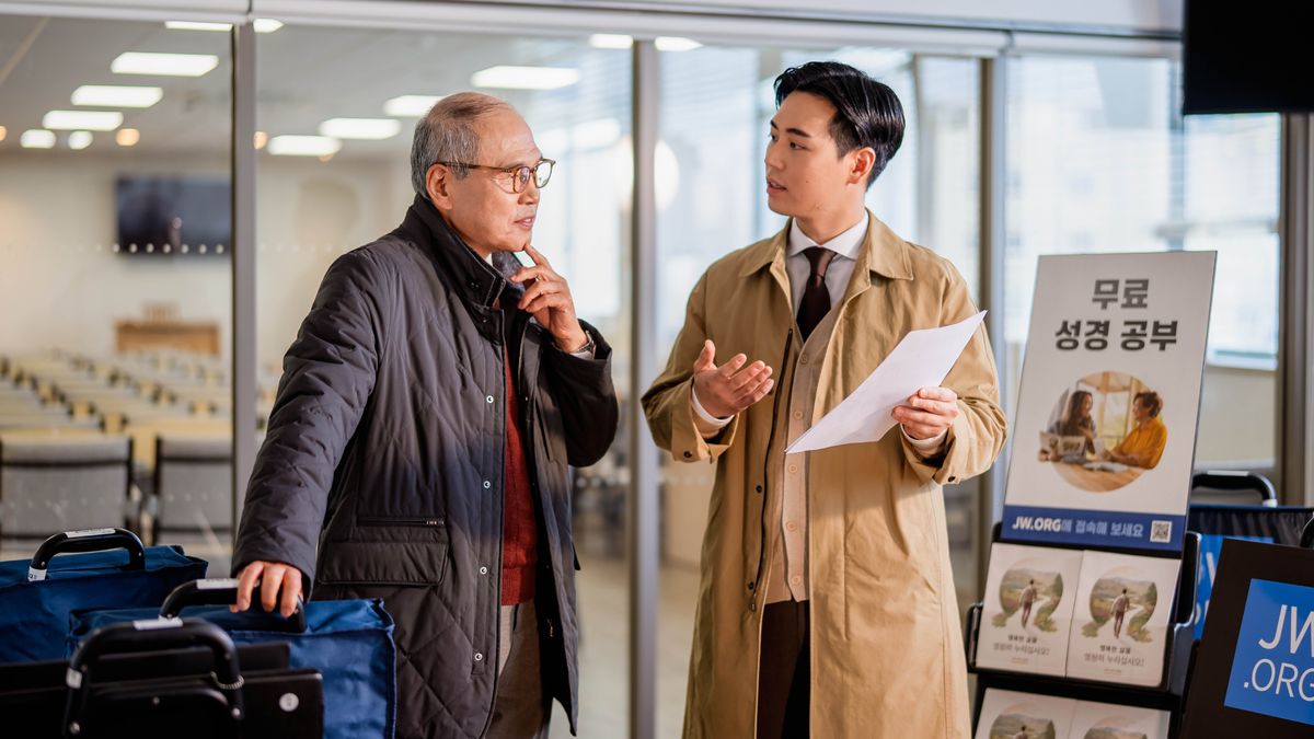 젊은 장로가 전시대를 어떻게 배치해야 하는지 설명하고 있습니다. 연로한 장로가 그의 말을 주의 깊이 듣고 있습니다.