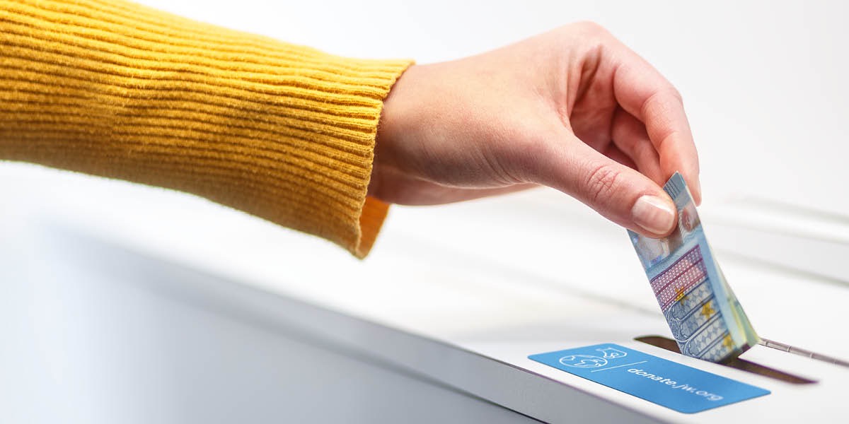 헌금함에 돈을 넣고 있는 여성