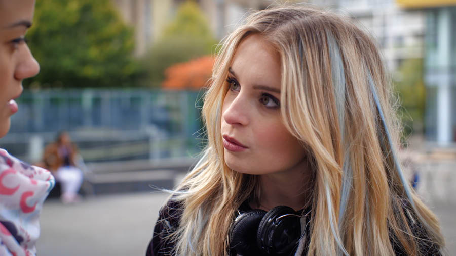 Ekifaananyi ekyaggibwa mu vidiyo, ‘Funa Essanyu Eriva mu Kufuula Abantu Abayigirizwa ng’Olongoosa mu Ngeri gy’Oyigirizaamu​—Kozesa Ebibuuzo.’ Shanita ng’addamu ekibuuzo Anita ky’amubuuzizza.