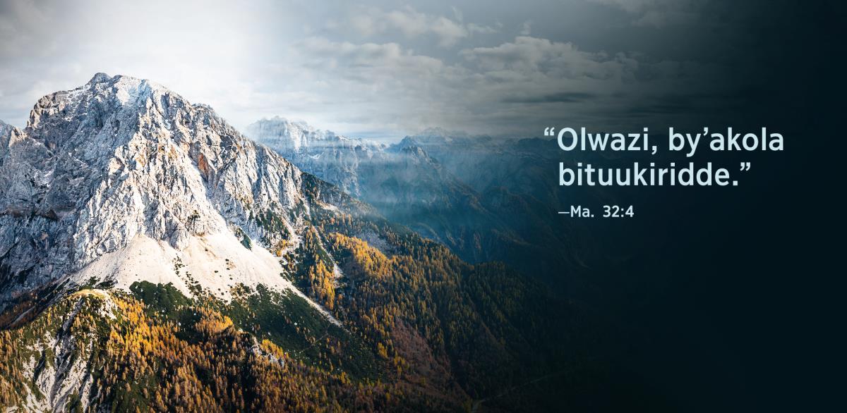 Ebigambo “Olwazi, by’akola bituukiridde,” okuva mu Ekyamateeka 32:4, nga biri kumpi n’olusozi.