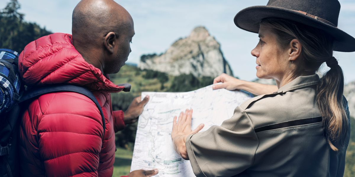 Omuvubuka eyalagiddwa mu kifaananyi ekyasoose ng’ayambibwa omukuumi. Akozesa maapu okumulaga ekkubo ly’alina okukwata okusobola okutuuka gy’alaga, ku ntikko y’olusozi.