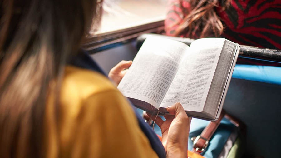Une sœur lit la Bible dans un bus.
