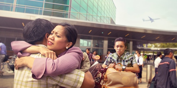 Marilyn and James hugging at the airport as their son Jimmy watches