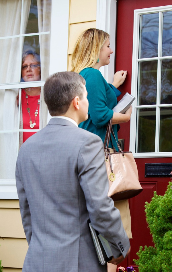 From her window, a woman observes Jehovah’s Witnesses knocking on her door