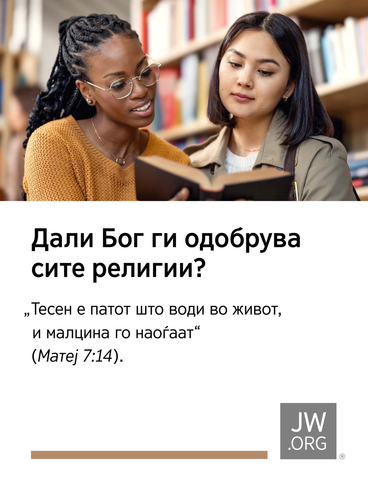 Две девојки заедно разгледуваат една книга во библиотека.