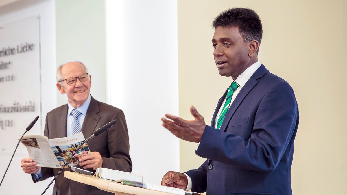 Еден помлад старешина го води проучувањето на „Стражарска кула“ додека еден постар брат, кој е читач, со насмевка гледа кон него.