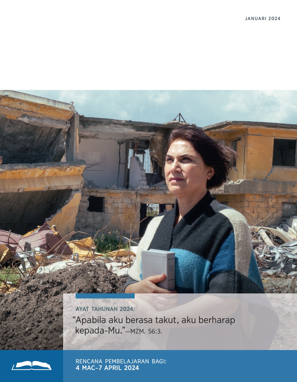 Seorang saudari memegang Bible dan berdiri dengan yakin di depan sebuah rumah yang musnah akibat bencana.