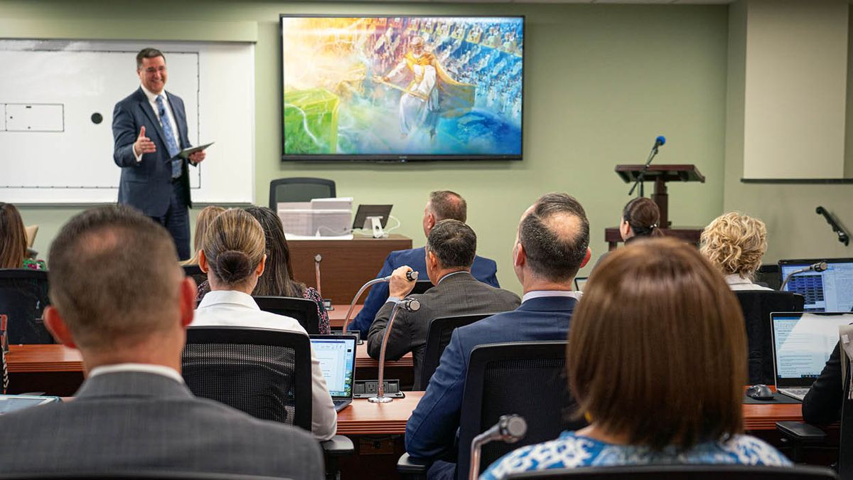 သင်တန်းပို့ချနေစဉ်။ ယေဟောဝါဘုရားဆီ ယေရှု နိုင်ငံတော် အပ်နှင်းနေတဲ့ ပန်းချီကို သင်တန်းပို့ချသူရဲ့အနောက်ဘက်က တီဗီဖန်သားပြင်ပေါ် မှာ တွေ့ရ။ သင်တန်းသားတွေက သူတို့စားပွဲပေါ်က မိုက်ကရိုဖုန်းနဲ့ မှတ်ချက်ပေးကြ။