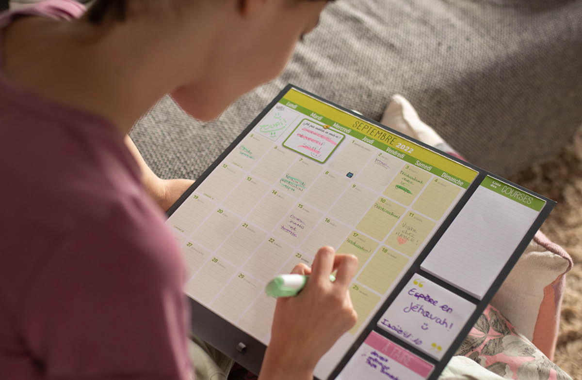 ဆယ်ကျော်သက် မိန်းကလေးတစ်ယောက် ပြက္ခဒိန်မှာ ကျမ်းစာ ဖတ်ရှုခြင်း ဇယား ချရေးနေ။