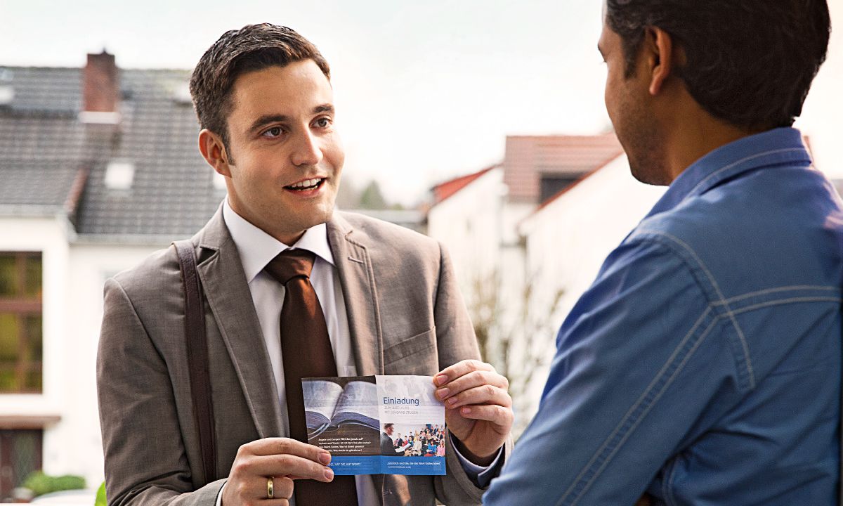 လူတစ်ယောက်ကို အသင်းတော်အစည်းအဝေးဖိတ်စာ ဝေငှနေတဲ့ ညီအစ်ကို