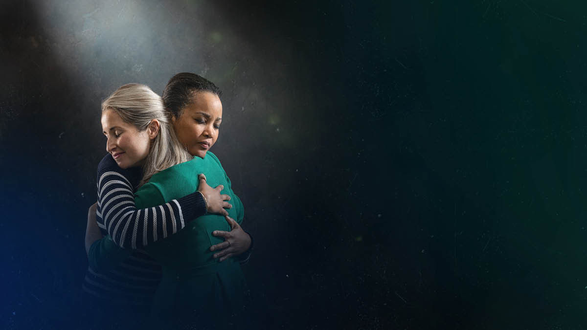 The words “The former things will not be called to mind,” from Isaiah 65:17, appearing next to two sisters who are hugging each other and showing expressions of relief.