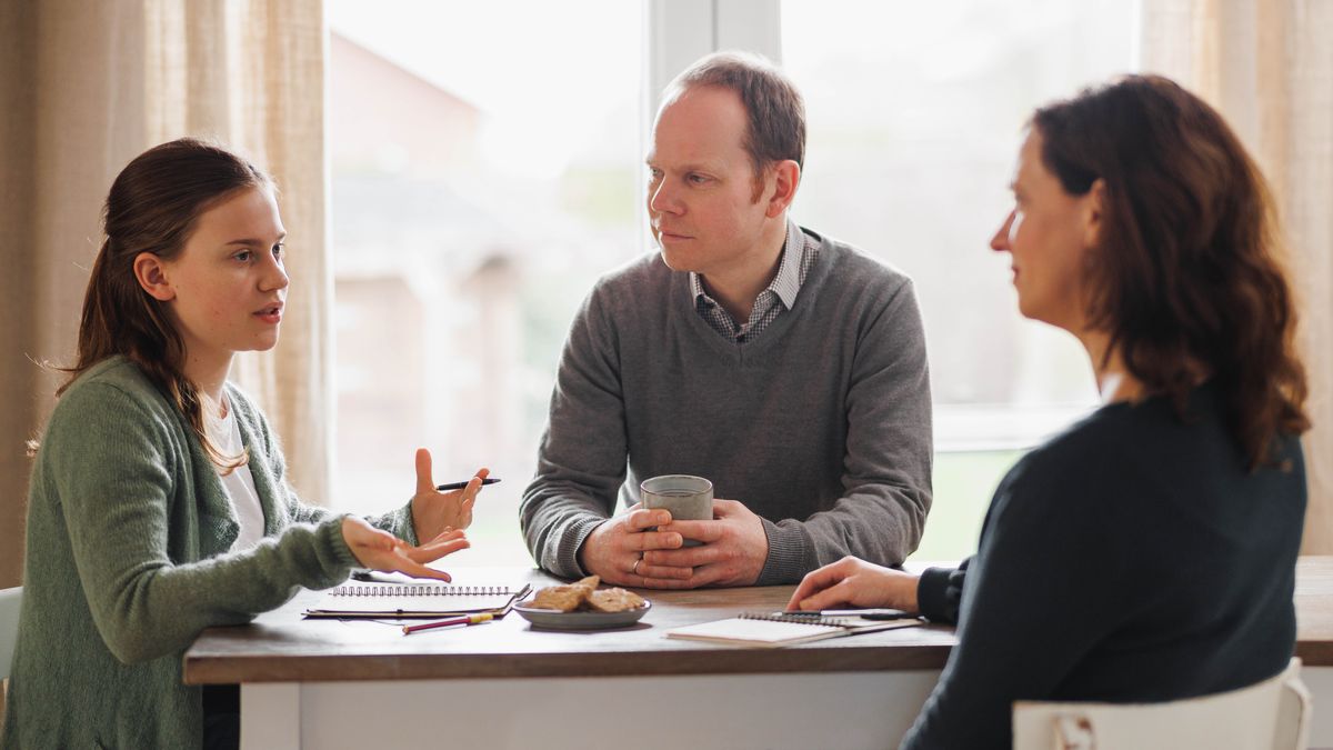 The girl from the previous image, expressing her feelings to her parents. Her parents are listening attentively.