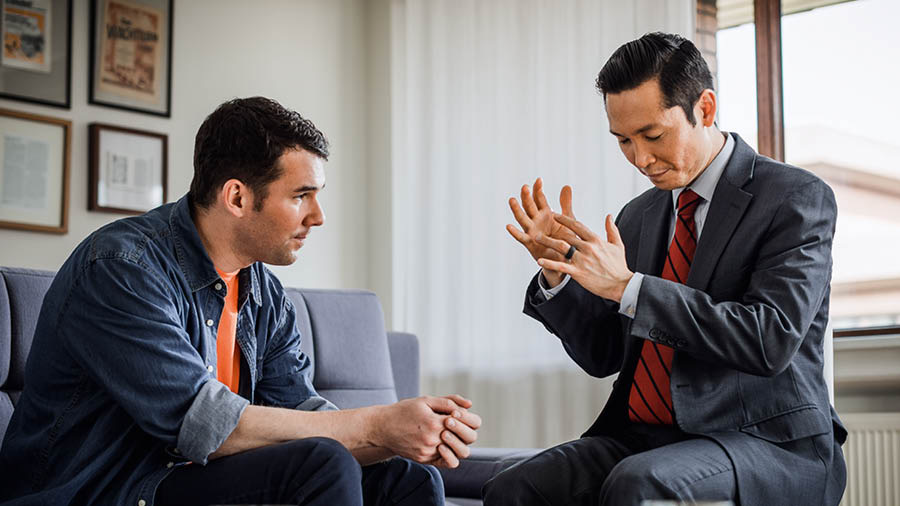 An elder praying with a brother who has returned to Jehovah.