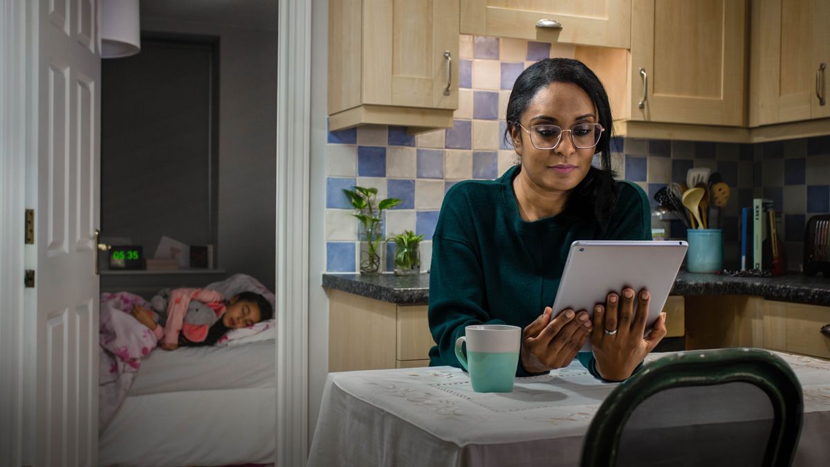A sister reading the Bible while her young daughter sleeps in a nearby bedroom.