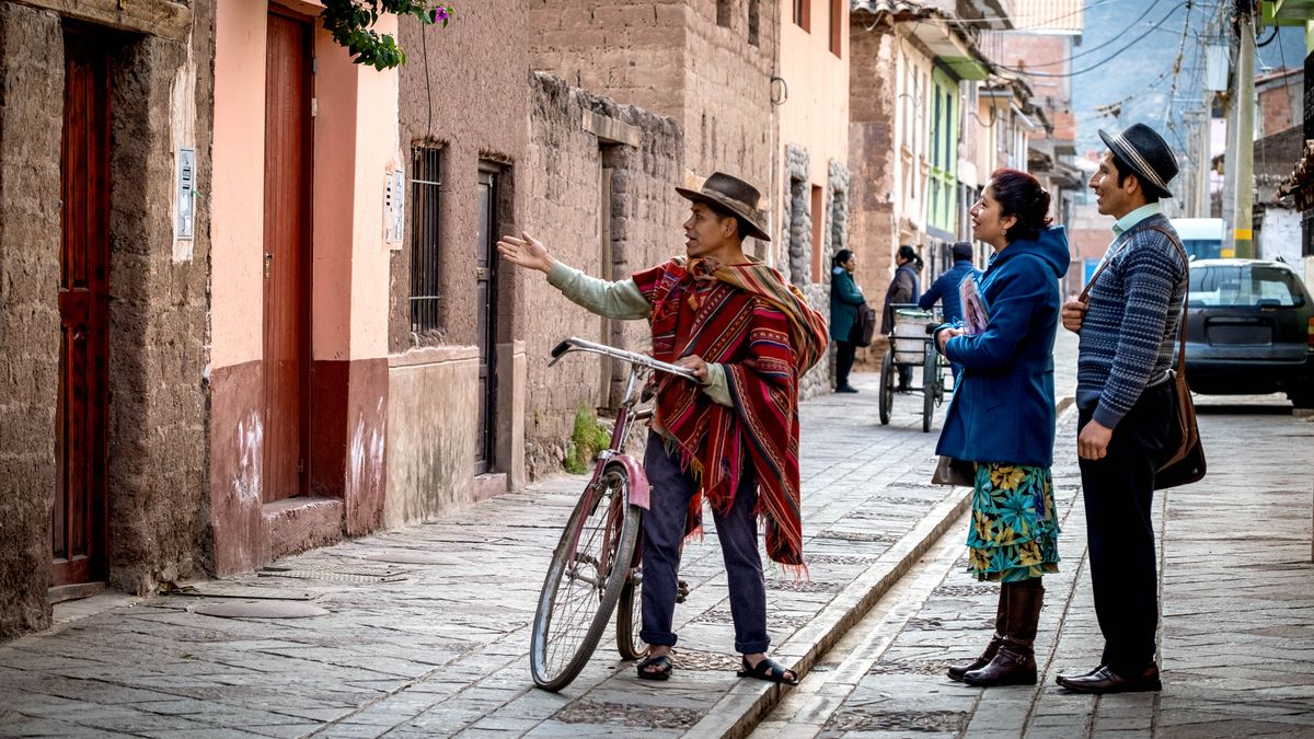 A Quechua-speaking man talking with a Witness couple who are in the ministry. He is showing them where someone lives.