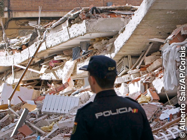 Policiais olhando destroços de prédios causados por terremoto