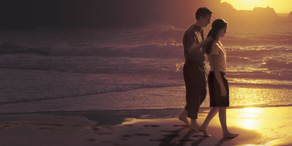 Um casal andando na praia