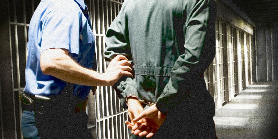 Тюремный охранник ведёт нашего брата в наручниках в камеру.