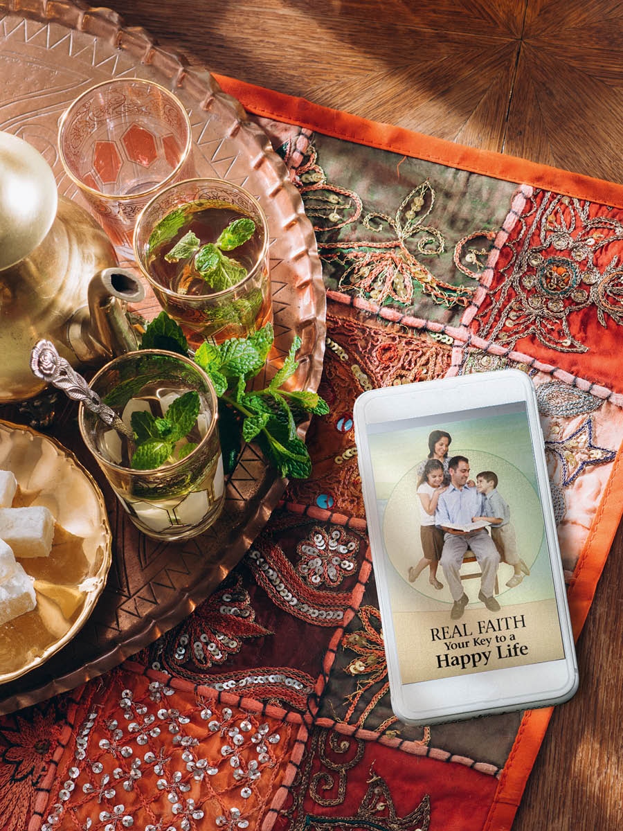 Terefone ngendanwa iri iruhande y’ibikombe bibiri birimwo agakawa. Muri iyo terefone, harimwo agatabu ‘Ukwizera nyakuri kurashobora gutuma ubaho uhimbawe.’