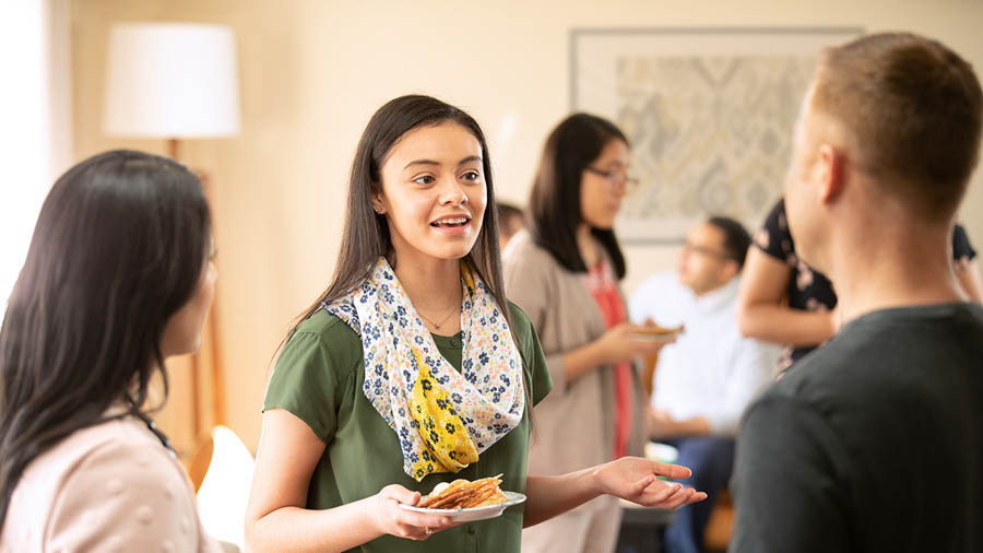 The same girl talking with a couple at the gathering.