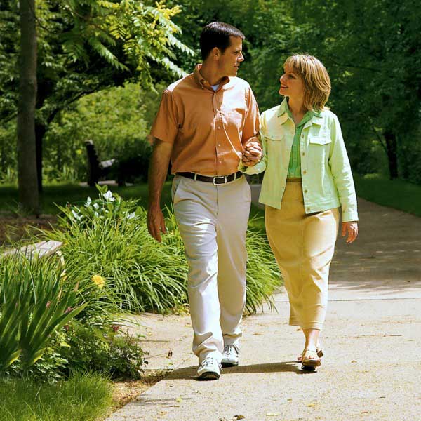A happy married couple strolling arm in arm in a park