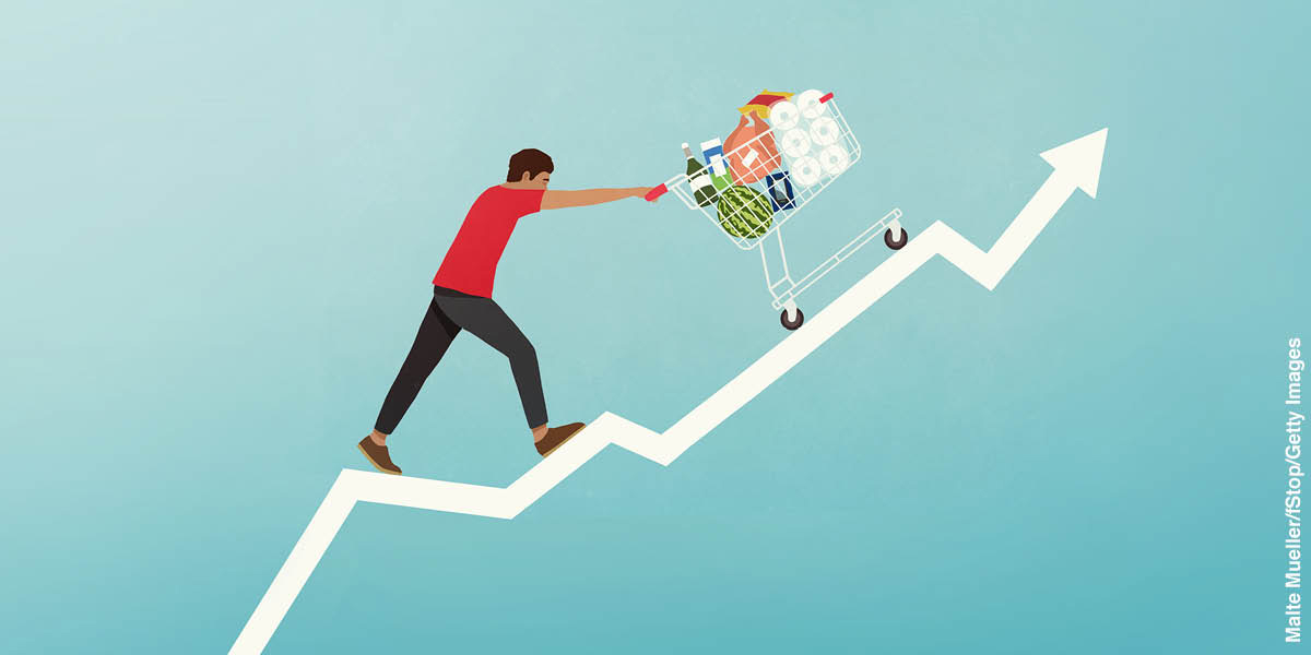 Graph with a line showing the steep increase in prices. A man is pushing a shopping cart full of groceries up the line.