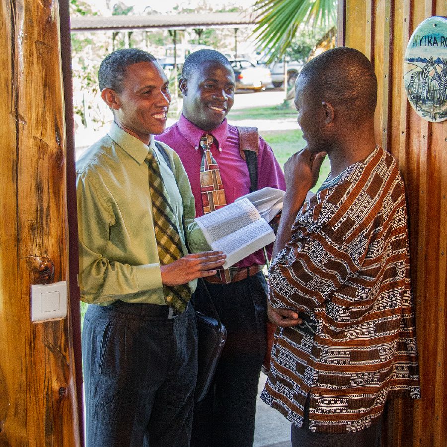 Two brothers in the door-to-door ministry share a scripture with a man