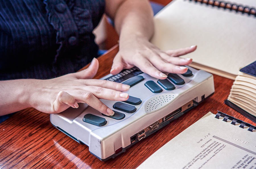 Collage: 1. A sister reading a braille publication. 2. A sister using a braille notetaker.