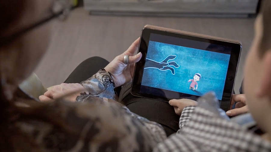 A scene from the video ‘Build a House That Will Endure​—Safeguard Your Children From ‘What Is Evil.’’ A mother and her son watch the video ‘Protect Your Children.’
