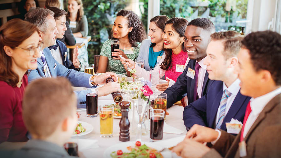 Brothers and sisters of various races eating a meal together after attending a convention.