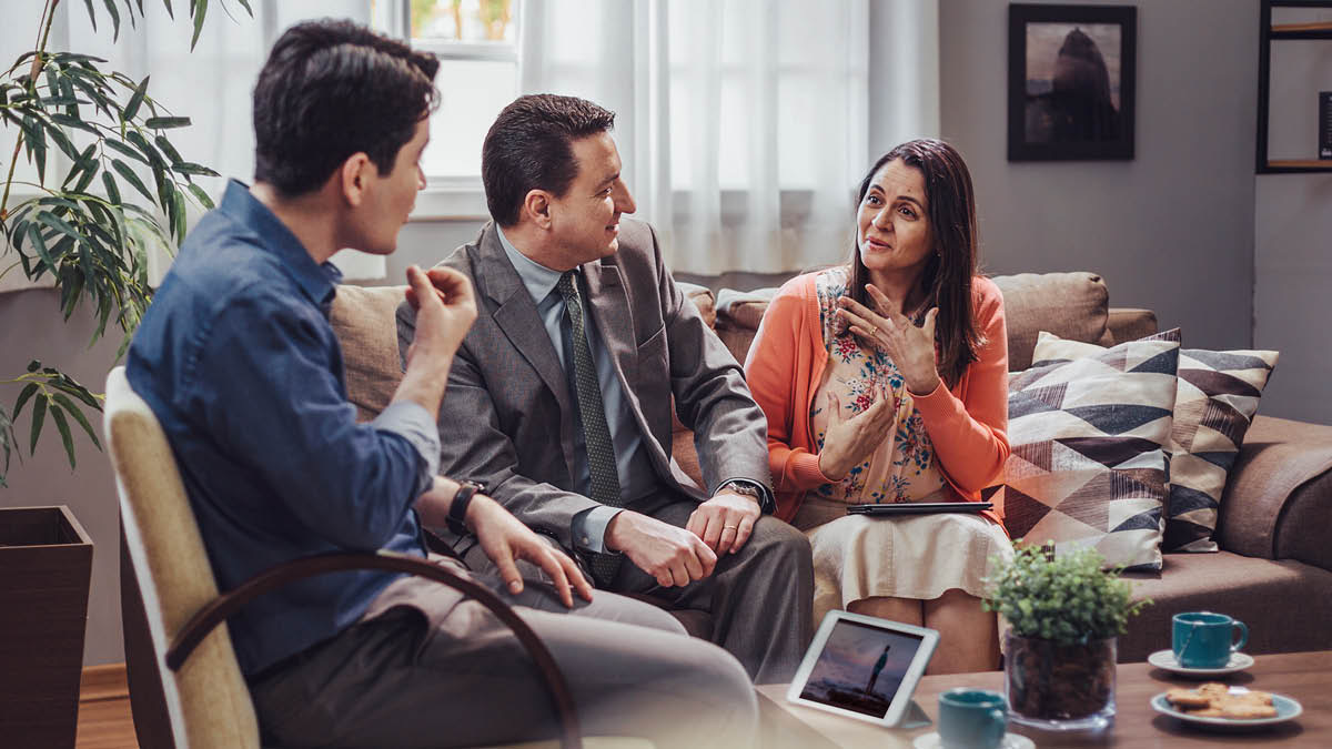 A brother, accompanied by his wife, using the “Enjoy Life Forever!” book to conduct a Bible study with a man.