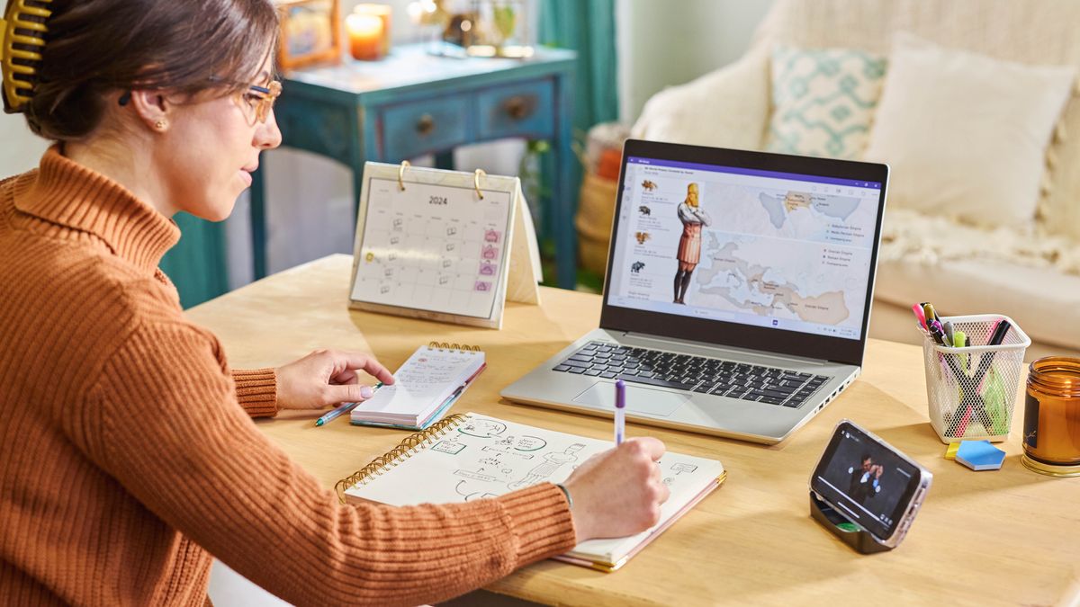 A sister using a laptop computer, a Bible, and a notebook to do personal Bible study. She uses the chart “World Powers Foretold by Daniel” in Appendix B9 of the “New World Translation.”