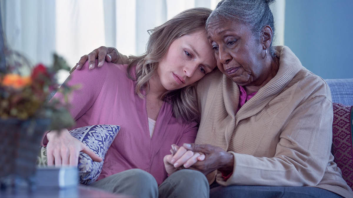 Une sœur âgée prend dans ses bras une jeune sœur pour la consoler.
